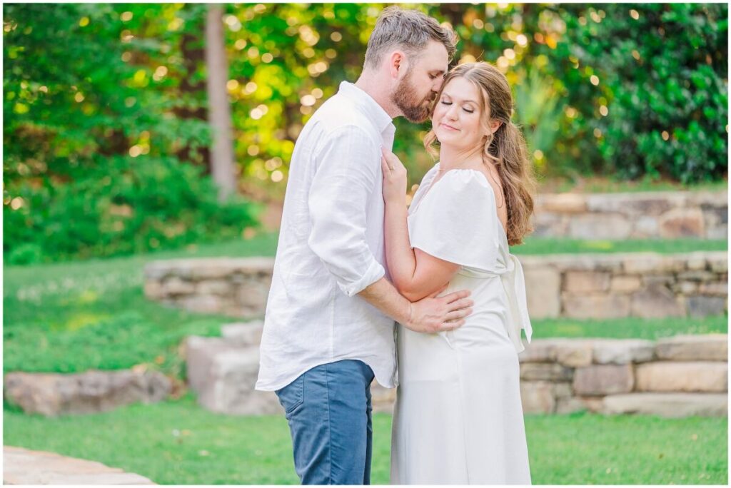 A happy brunette couple enjoying their Duke Gardens engagement photos in the vibrant greenery by JoLynn Photography