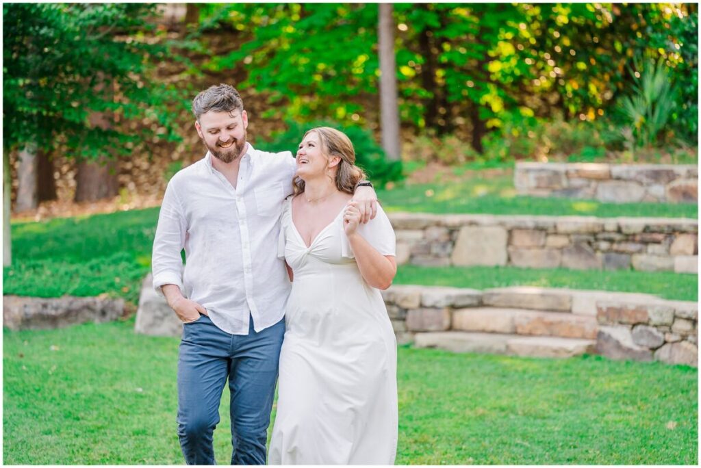 A happy couple enjoying their summertime engagement session in a popular Raleigh garden