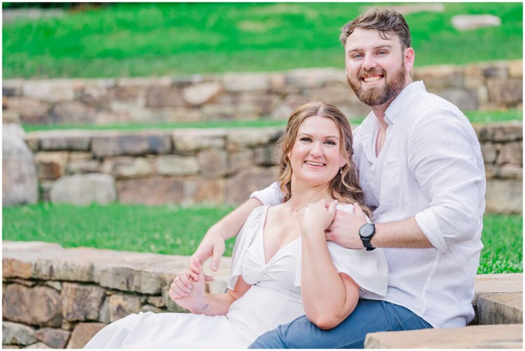 A happy couple enjoying their summertime engagement session in a popular Raleigh garden