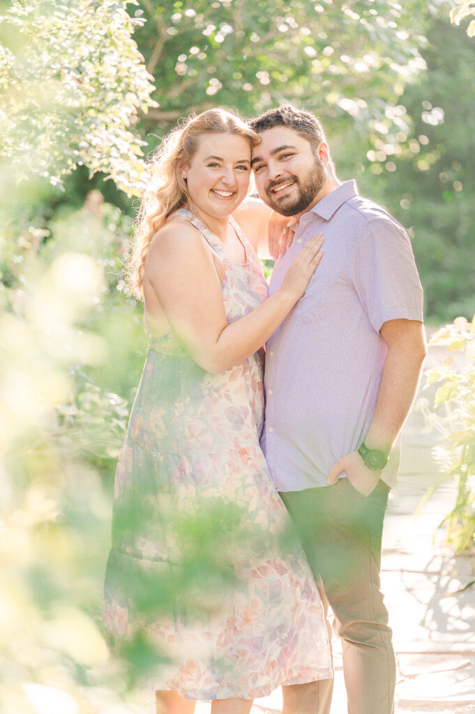 A happy couple during sunset at a downtown Raleigh garden during their Raleigh engagement photography session with JoLynn Photography