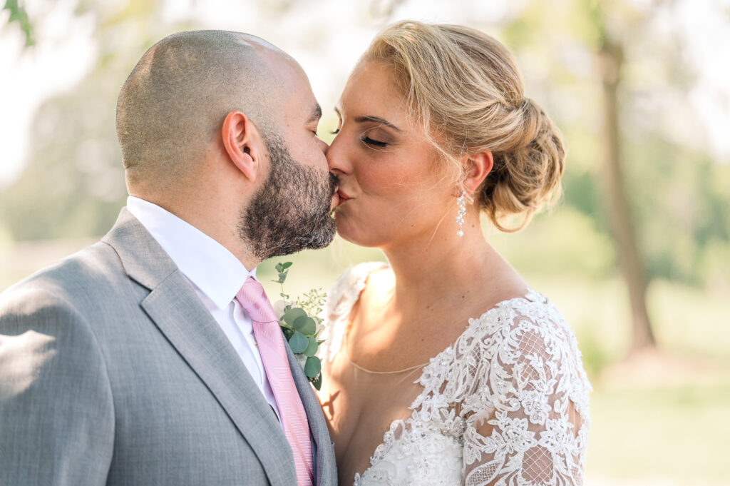 A loving couple kissing after their fall wedding ceremony in the Raleigh countryside by JoLynn Photography