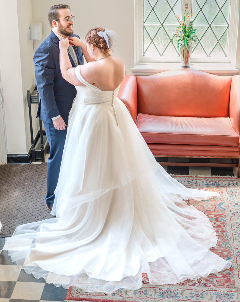 A loving couple enjoying their first look at an indoor Raleigh wedding by JoLynn Photography