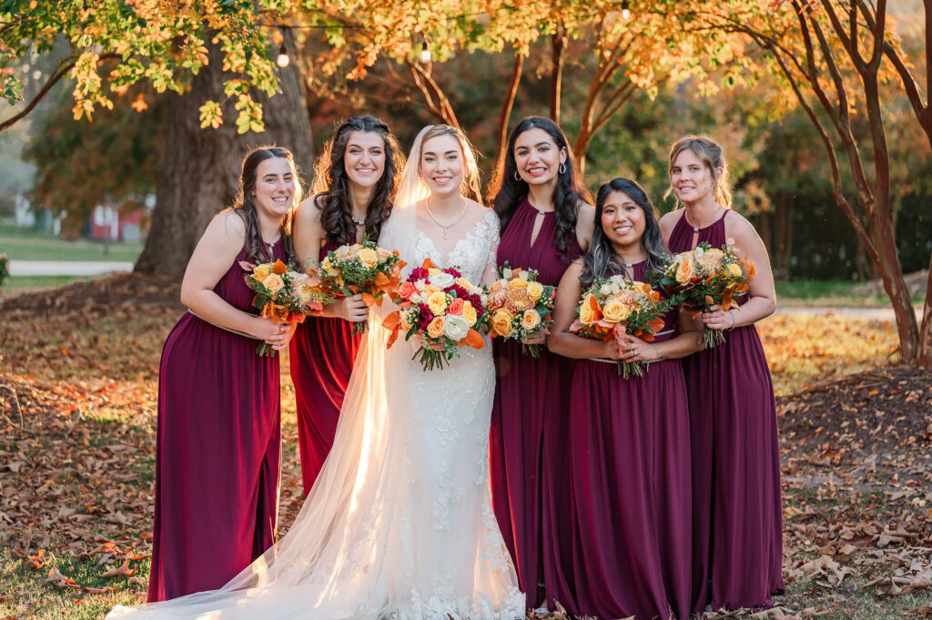 A happy bride and her bridesmaids during her fall wedding