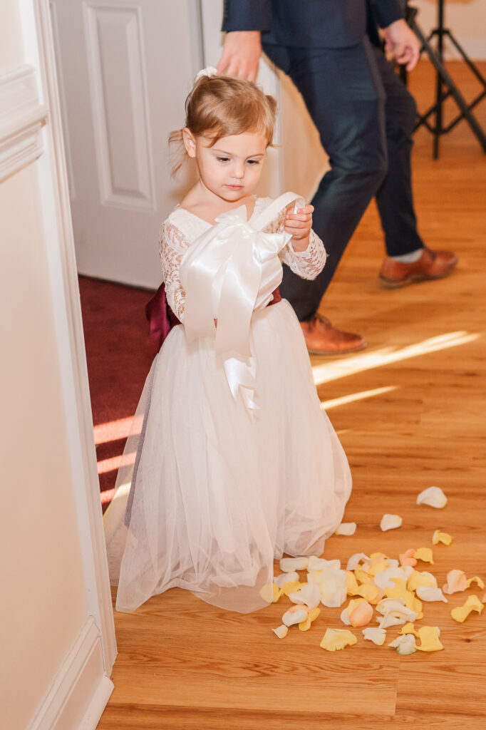 A precious flower girl dropping her rose petals as she goes down the isle at the Hudson Manor