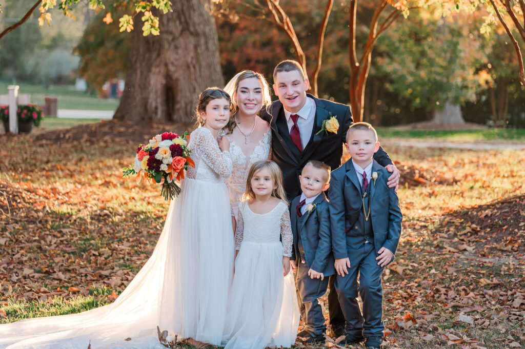 A bride and groom with their flower girls and ring bearers at the Hudson Manor