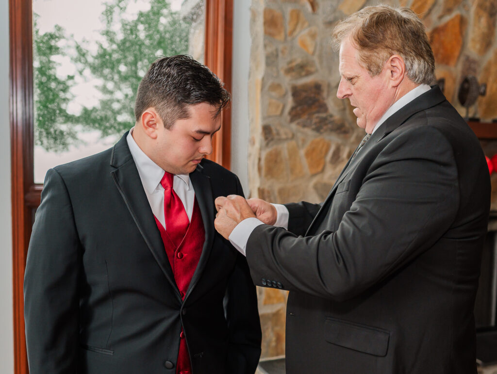 A groom and his dad helping him get ready for his Lake Gaston Wedding by JoLynn Photography