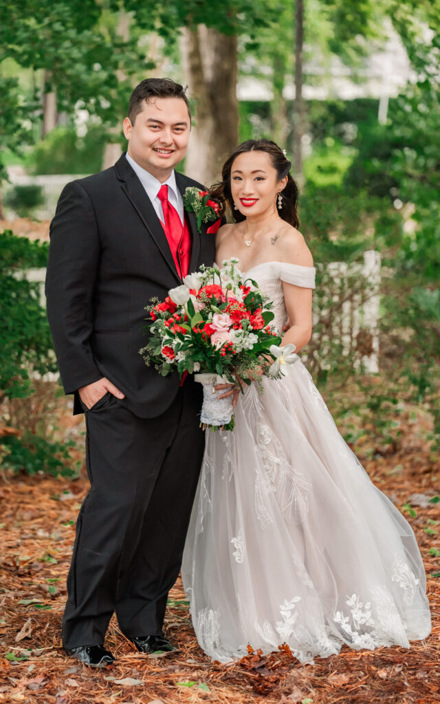 A happy newly wed Asian couple at sunset overlooking the water at their Lake Gaston Wedding by JoLynn Photography