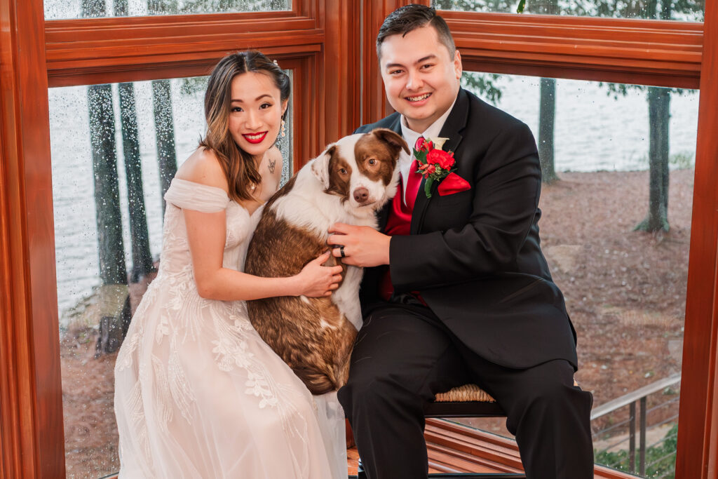 A happy newly wed couple with their puppy at their Lake Gaston wedding