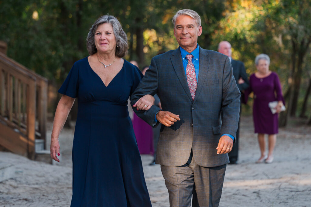 A wedding party entering the wedding ceremony at the River Landing wedding venue by JoLynn Photography