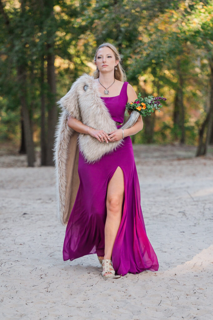 A bridesmaid dressed in Viking attire walking down the aisle at the River Landing wedding venue