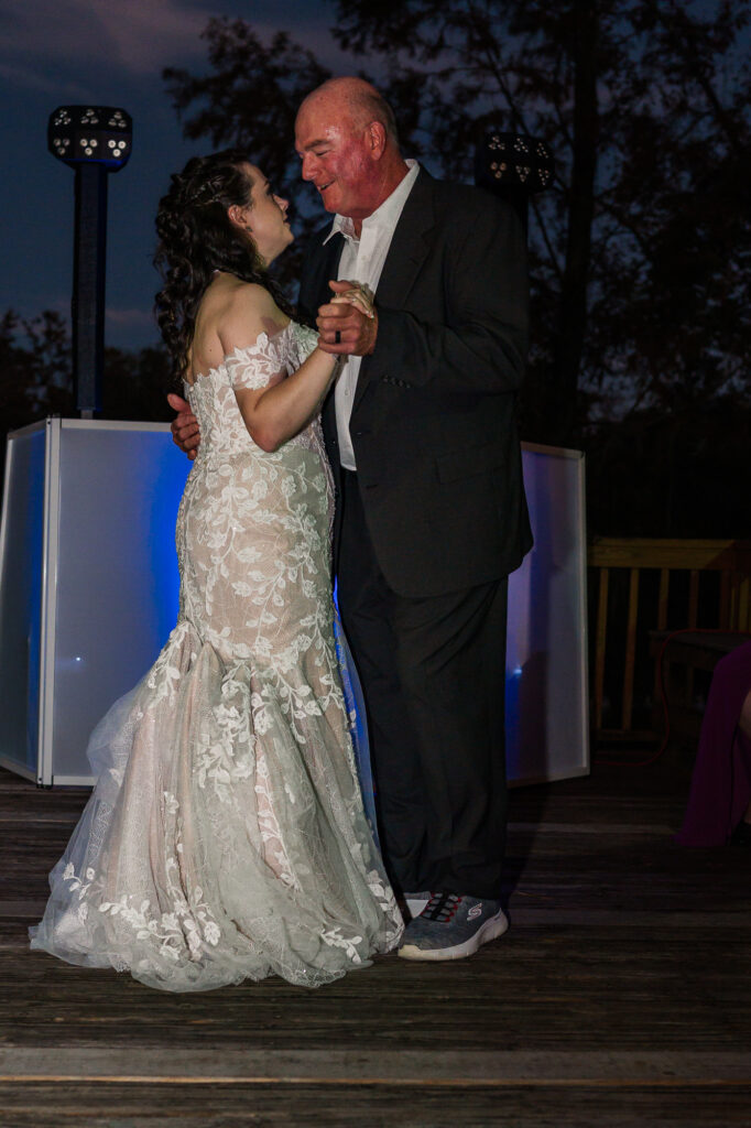 A bride and her dad during a father daughter dance at the River Landing wedding venue by JoLynn Photography