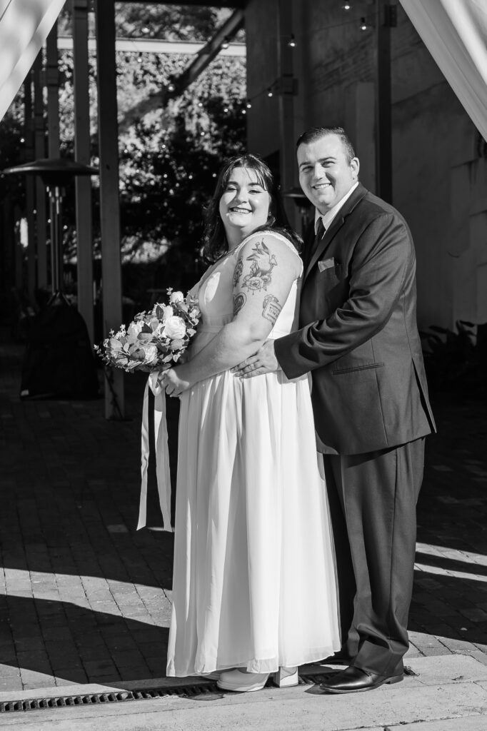 A newly wed bride and groom outside the Atrium Wedding Venue by JoLynn Photography