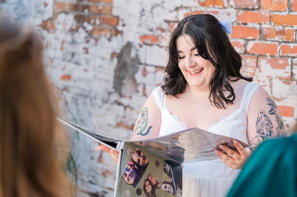A bride looking at a surprise wedding book her bridesmaids made her at The Atrium Wedding Venue