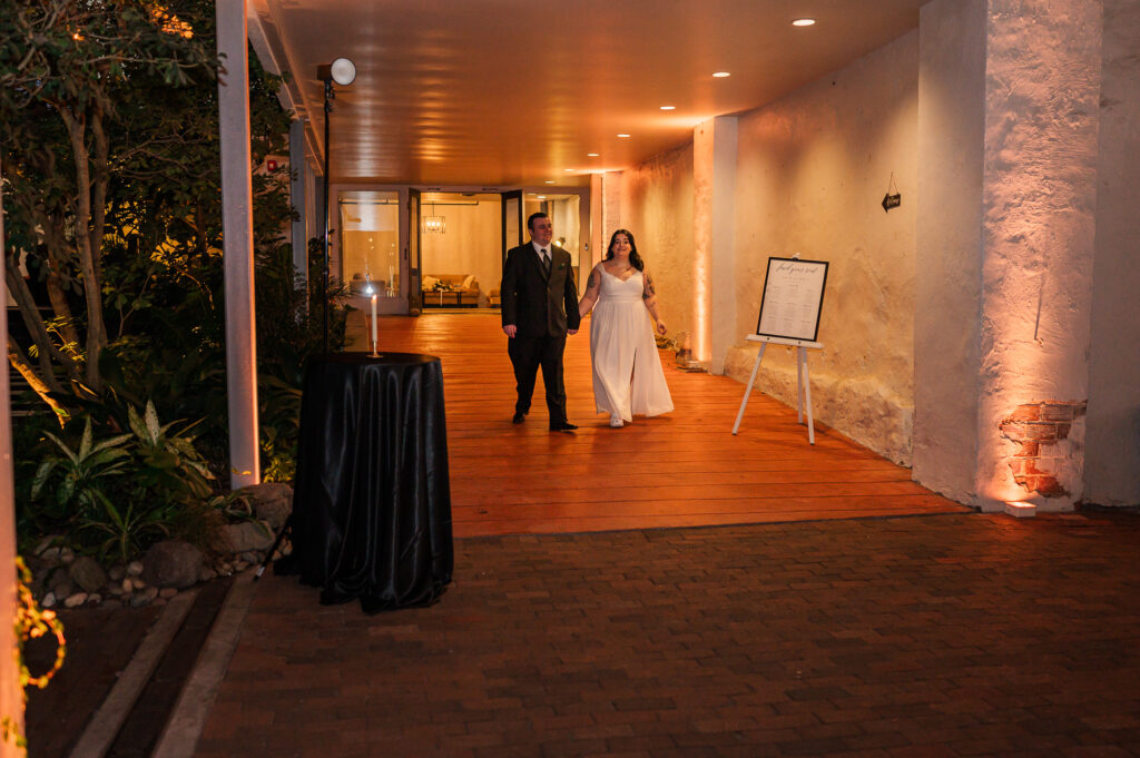 A happy bride and groom entering their wedding reception