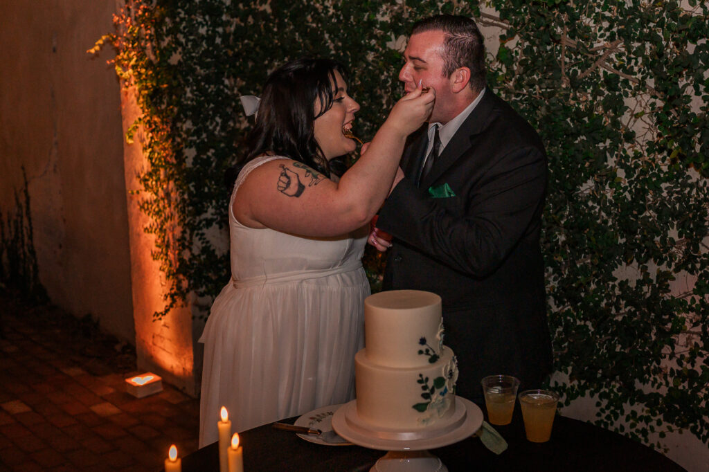 A bride and groom feeding each other cake after an amazing wedding day at The Atrium Wedding Venue by JoLynn Photography