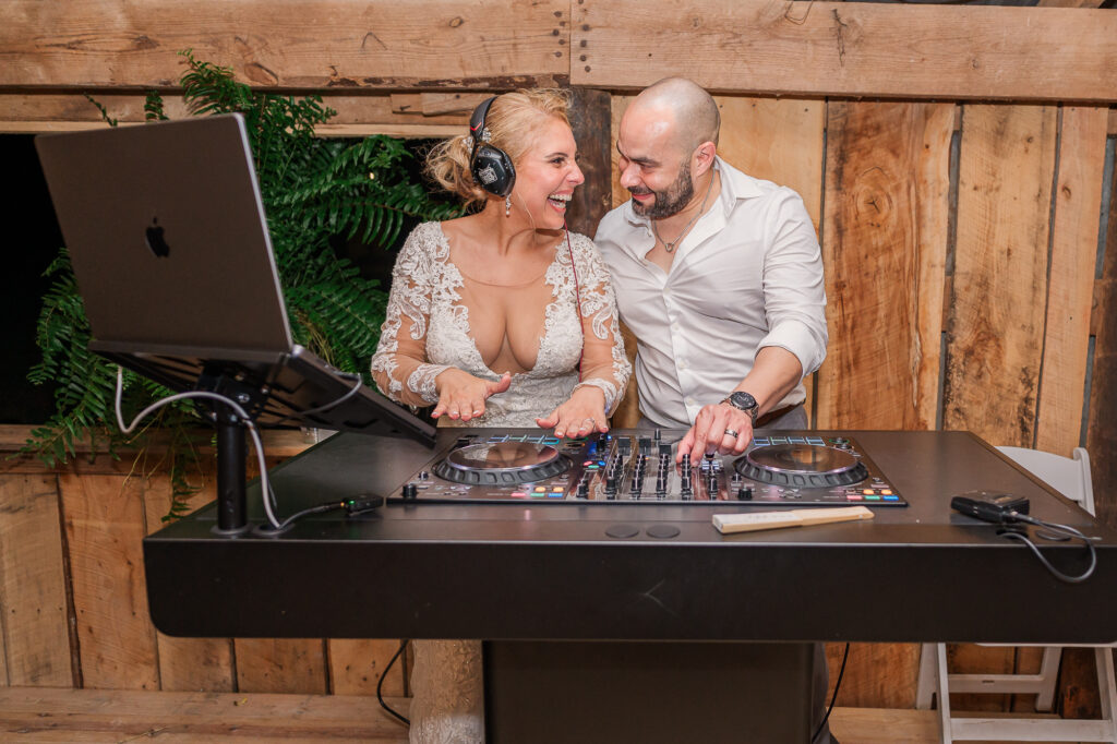 A couple having fun during their wedding reception at the DJ turn table by JoLynn Photography