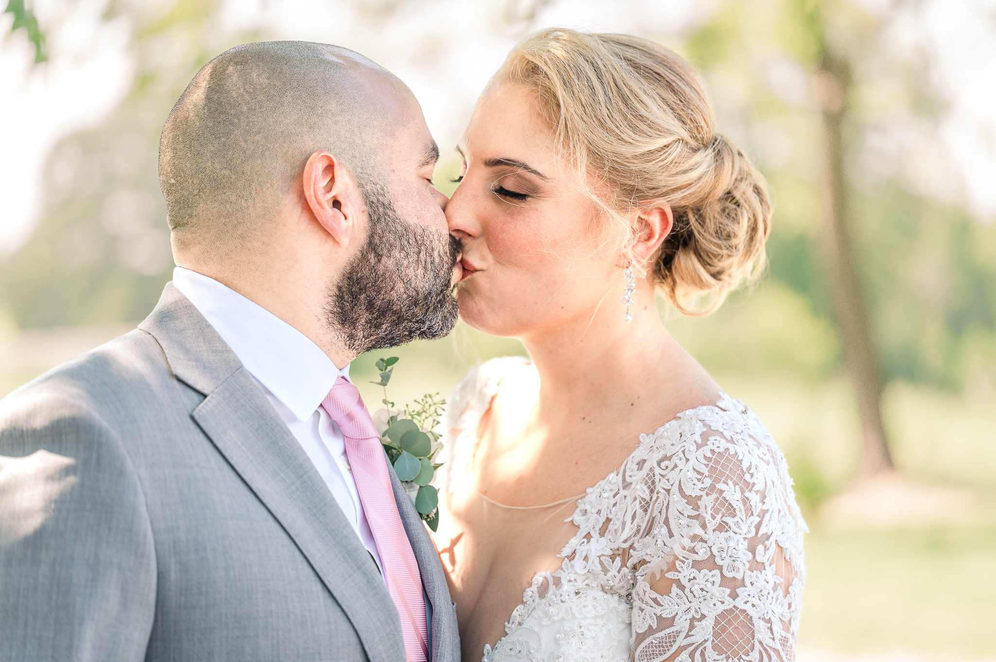 A couple kissing at Boots and Roots farm on their wedding day by JoLynn Photography