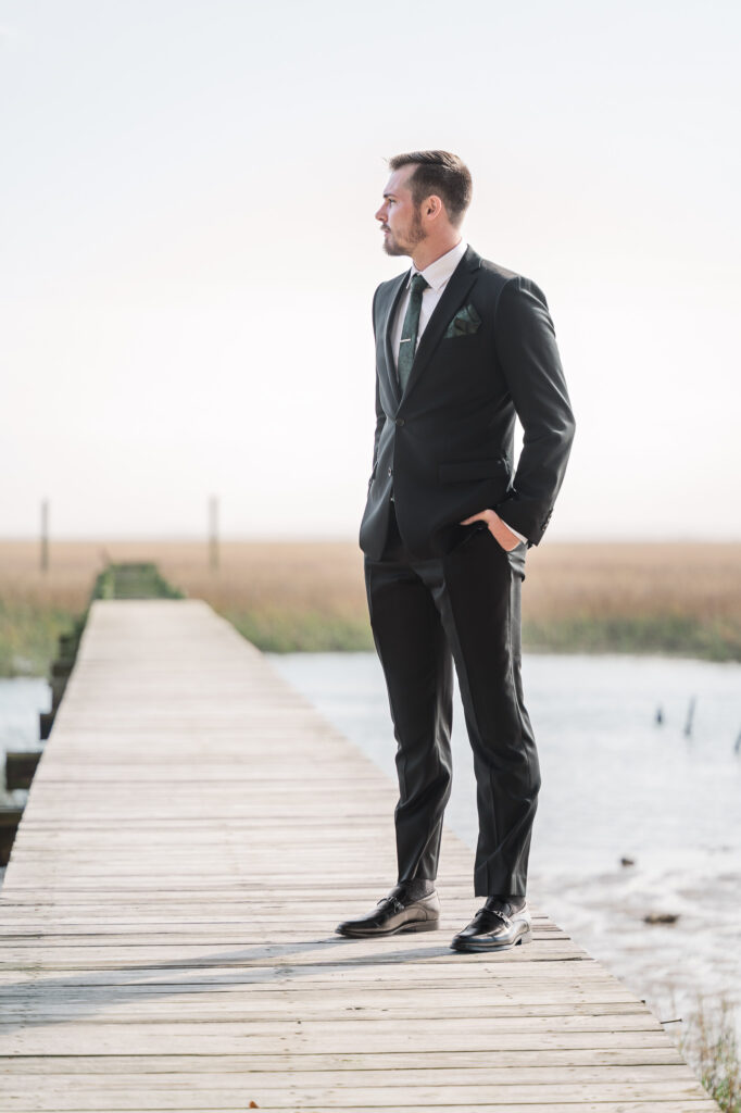 A groom overlooking the Intracoastal waterway at a Savannah Destination Wedding by JoLynn Photography