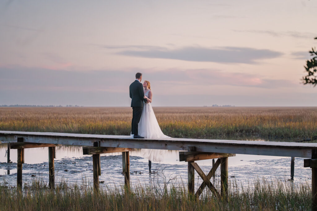 A newlywed couple overlooking the intercoastal waterways at sunset in Beaufort by JoLynn Photography