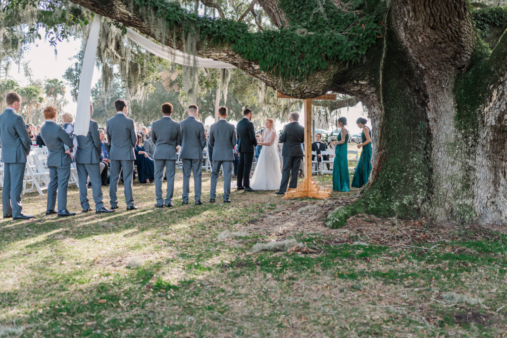 A bride, groom, and the wedding party under Spanish moss trees in Beaufort on their wedding day