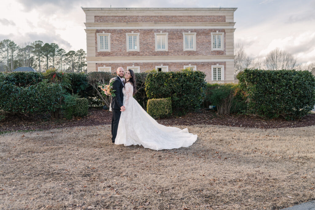 A newly wed couple hugging outside the Oxbow Estate by JoLynn Photography