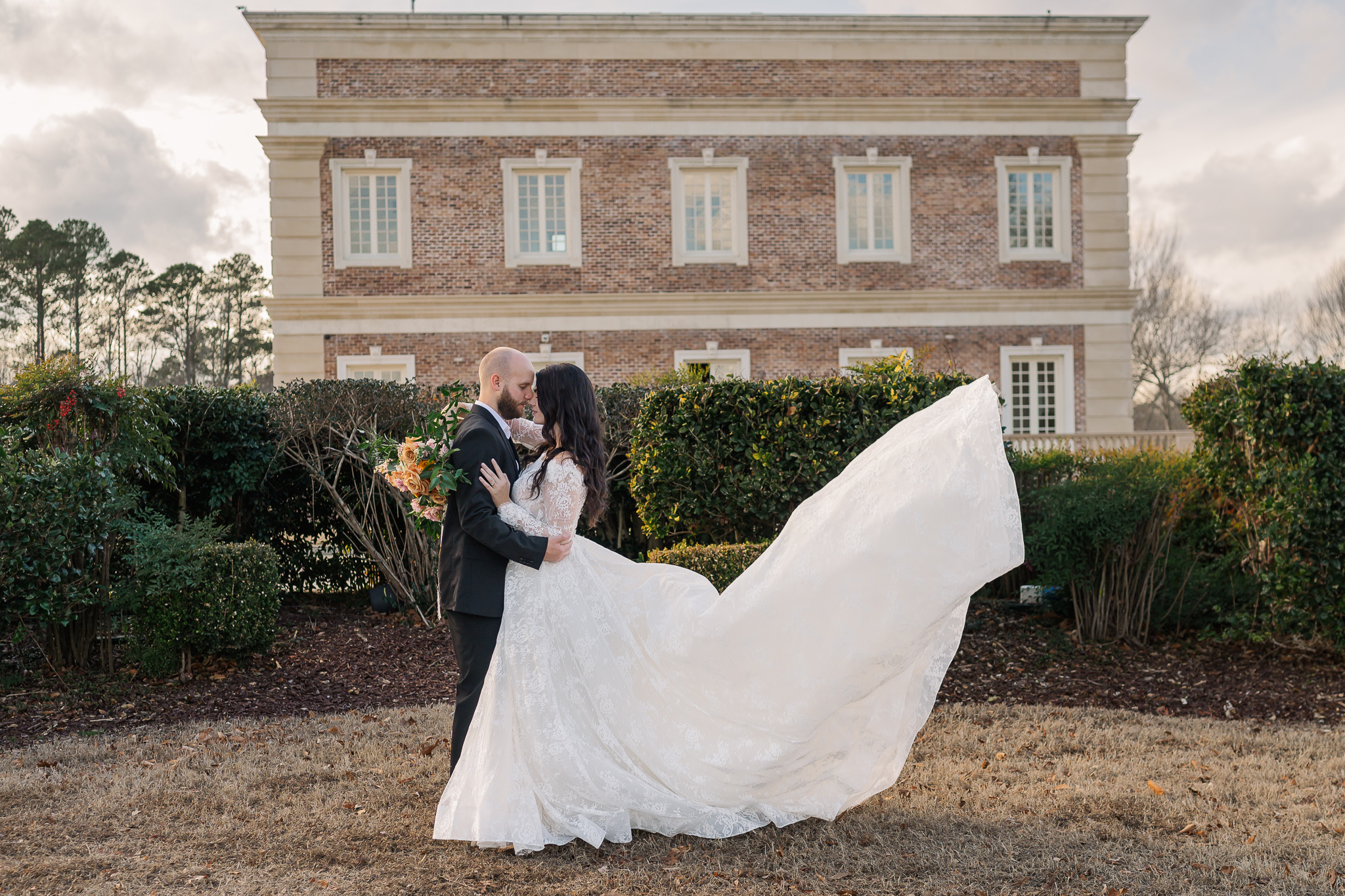 A couple holding each other outside The Oxbow Estate by JoLynn Photography