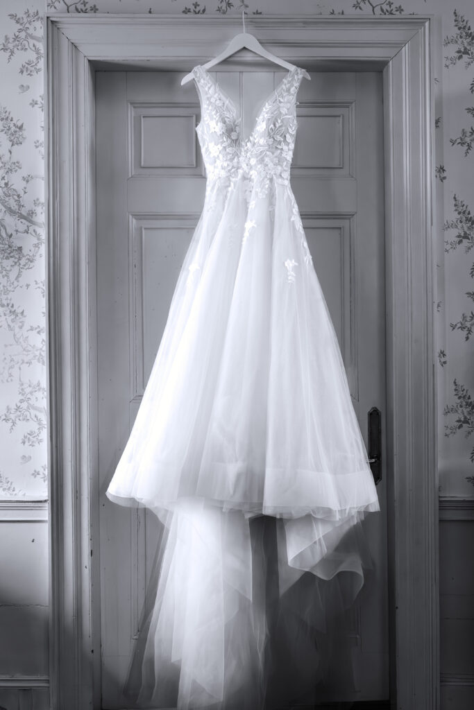 A wedding gown hanging in the Main House at Agapae Oaks by JoLynn Photography