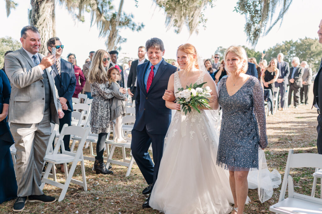A bride walking down the aisle with her parents at a Savannah Destination Wedding by JoLynn Photography