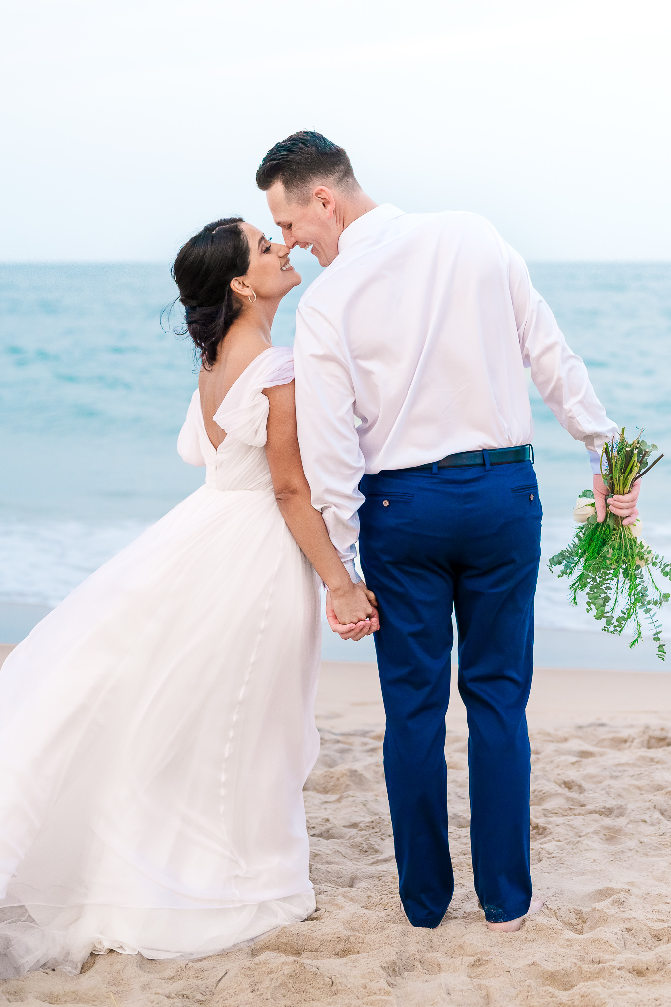 A couple kissing on Wrightsville beach during their Wilmington NC wedding by JoLynn Photography