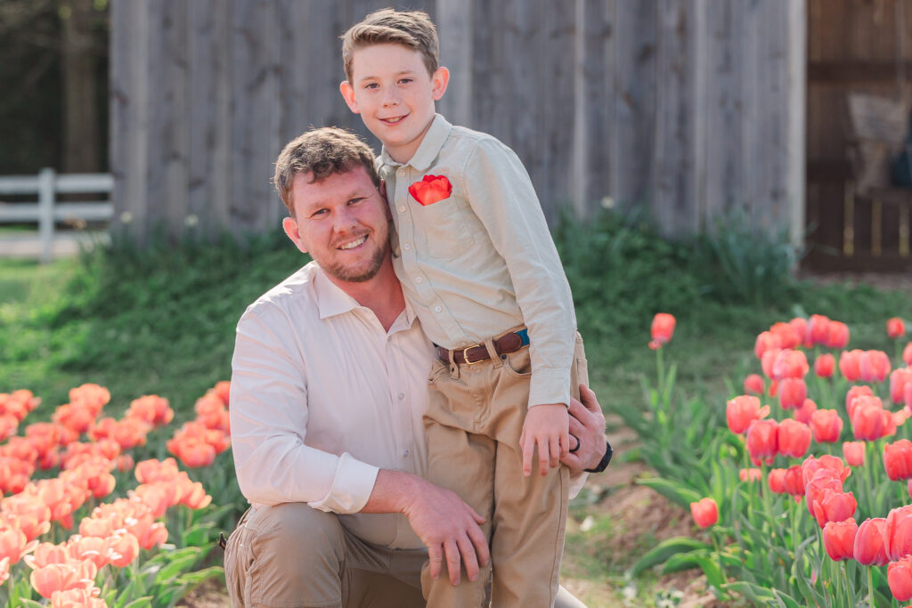 A loving father and his son within endless fields of tulips outside of Greensboro by JoLynn Photography, a Greensboro family photographer
