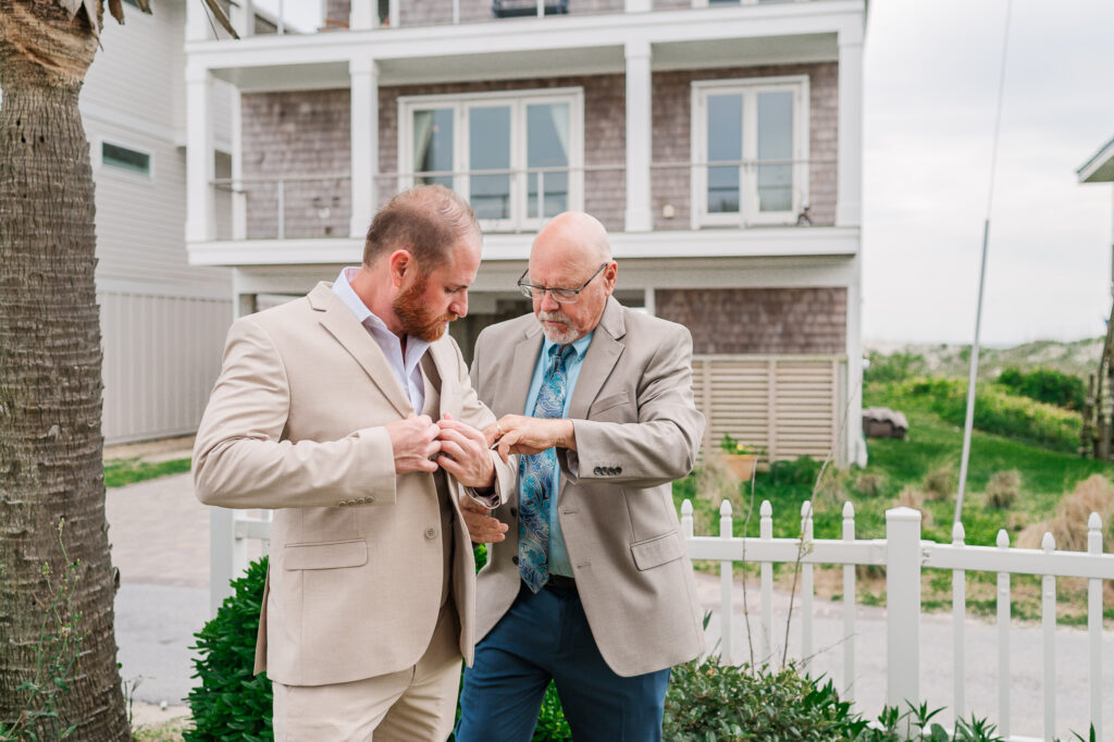 A father helping his son get ready for his Atlantic beach wedding by JoLynn Photography