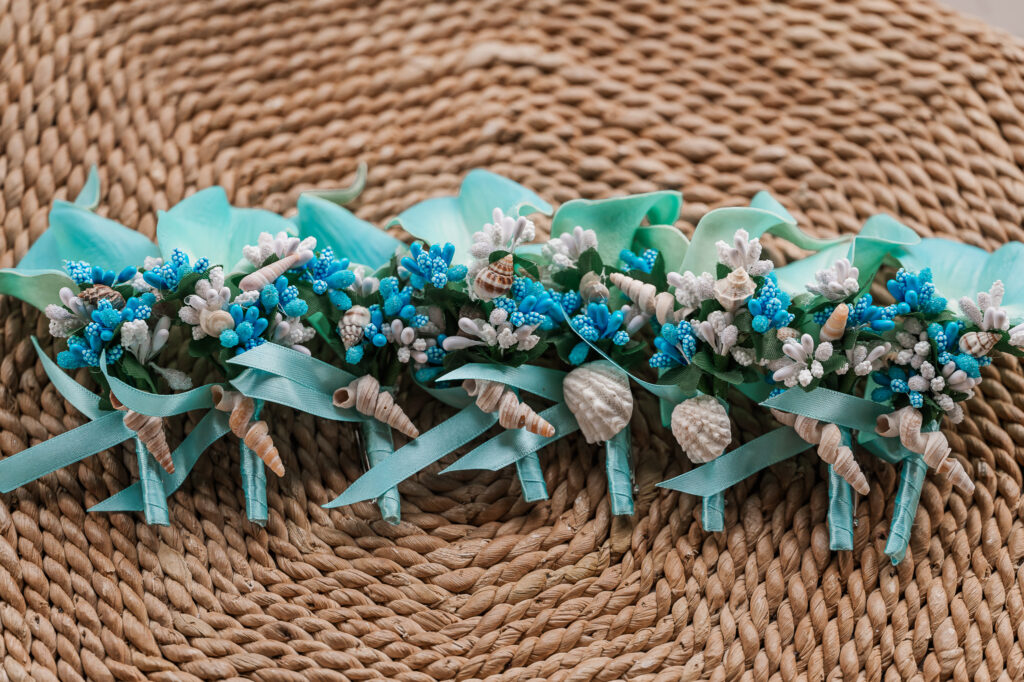 Teal beach-themed boutonnieres for groomsmen
 
