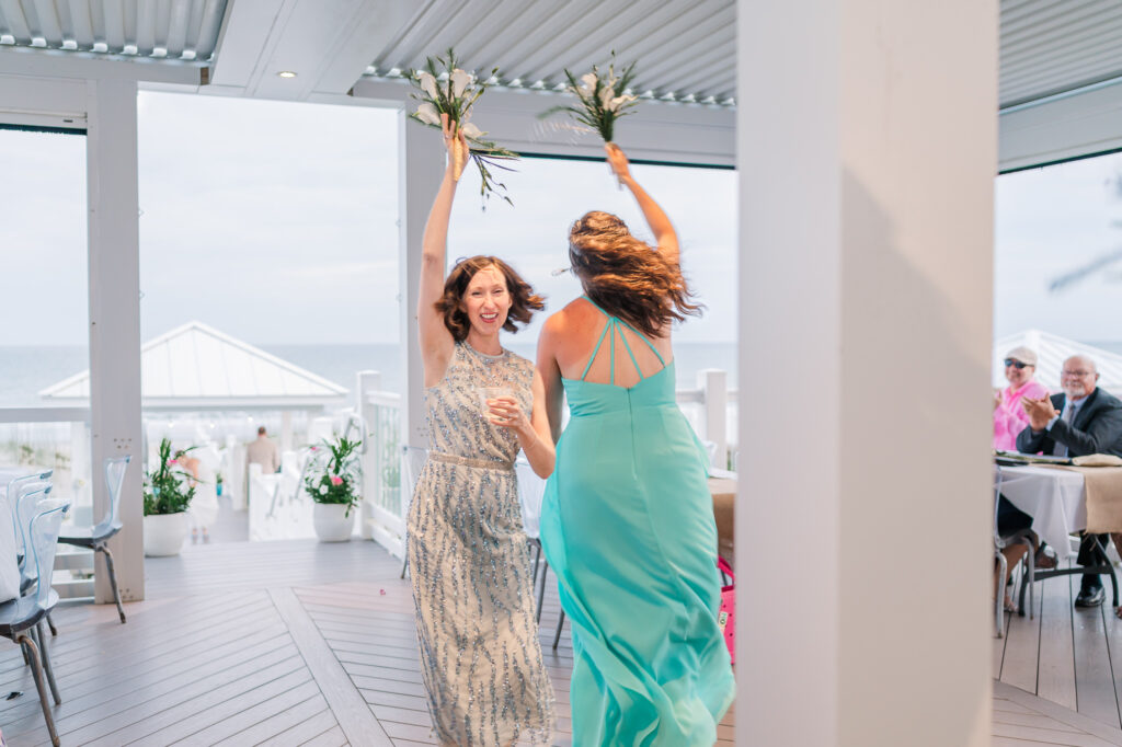 Two happy bridesmaids entering an Atlantic Beach wedding reception by JoLynn Photography
