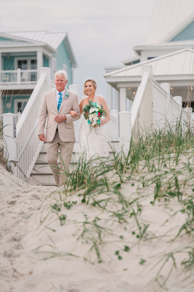 A bride walking down a beachside aisle with her dad at her Atlantic beach wedding by JoLynn Photography