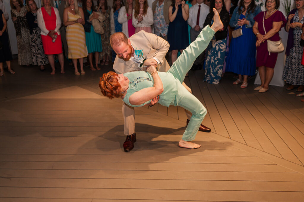A mother of the groom dancing with her son at his Atlantic beach wedding
