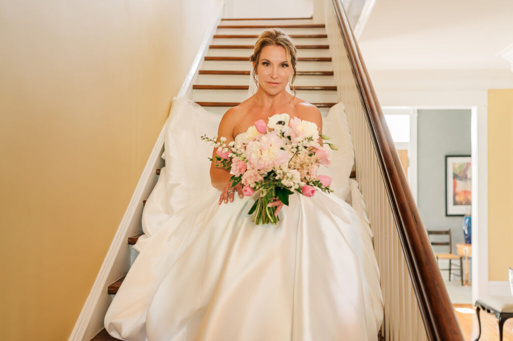 A brunette bride on a staircase for her bridal portraits at Highrock Farms by JoLynn Photography