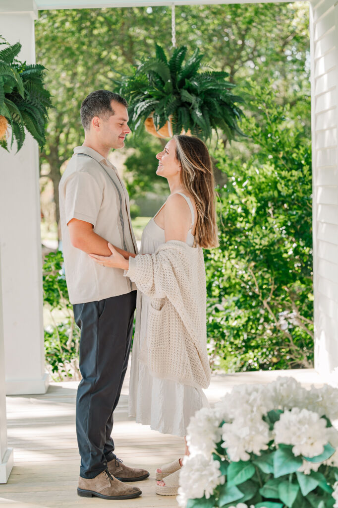 A happy couple staring deeply into each other's eyes on the porch during the spring time enjoying their Sycamore Bend engagement