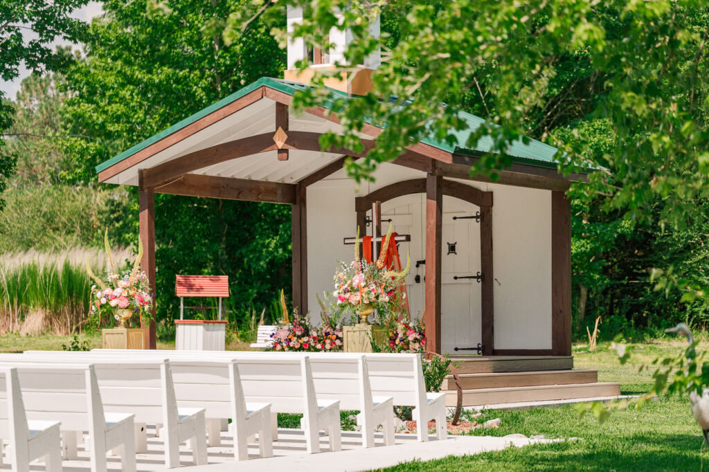 An outdoor wedding ceremony space in garden at The English Country Barn by JoLynn Photography