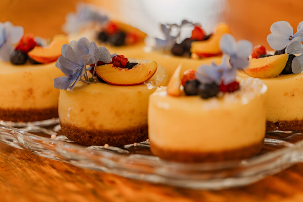 A row of decadent desserts during a wedding reception at The English Country Barn by JoLynn Photography