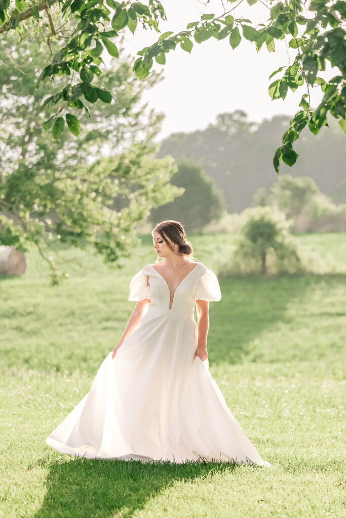 A playful brunette bride enjoying her summer outdoor bridal portrait session at Firefly Haven by JoLynn Photography