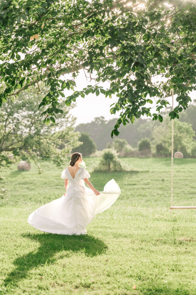 A playful brunette bride enjoying her summer outdoor bridal portrait session at Firefly Haven by JoLynn Photography