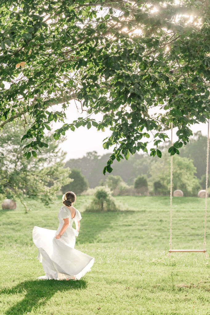 A playful brunette bride enjoying her summer outdoor bridal portrait session at Firefly Haven by JoLynn Photography