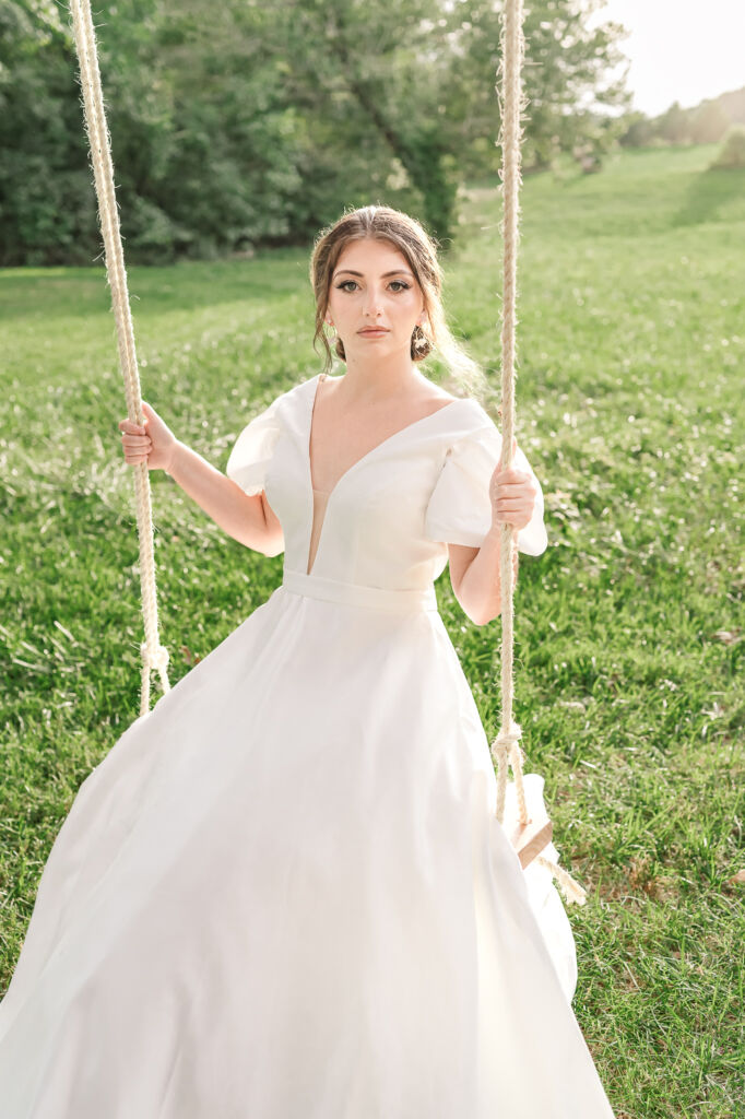 A playful brunette bride enjoying her summer outdoor bridal portrait session at Firefly Haven by JoLynn Photography