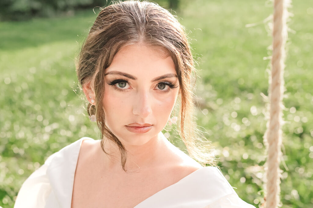 A playful brunette bride enjoying her summer outdoor bridal portrait session at Firefly Haven by JoLynn Photography