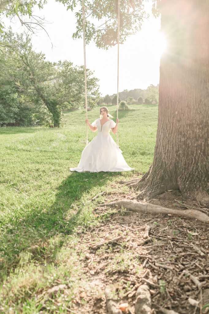 A playful brunette bride enjoying her summer outdoor bridal portrait session at Firefly Haven by JoLynn Photography