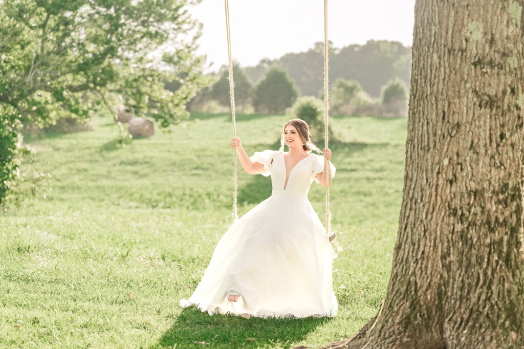 A playful brunette bride enjoying her summer outdoor bridal portrait session at Firefly Haven by JoLynn Photography