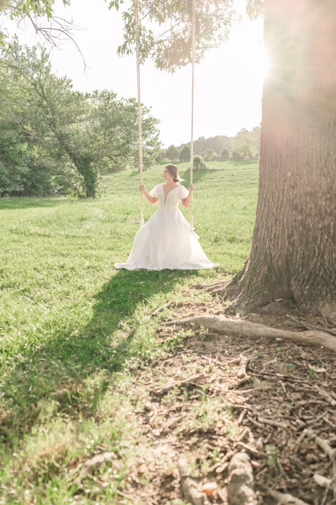 A playful brunette bride enjoying her summer outdoor bridal portrait session at Firefly Haven by JoLynn Photography