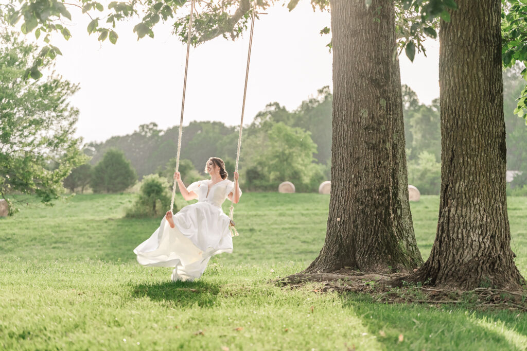 A playful brunette bride enjoying her summer outdoor bridal portrait session at Firefly Haven by JoLynn Photography