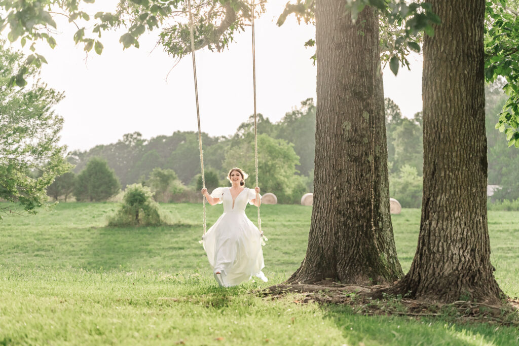 A playful brunette bride enjoying her summer outdoor bridal portrait session at Firefly Haven by JoLynn Photography