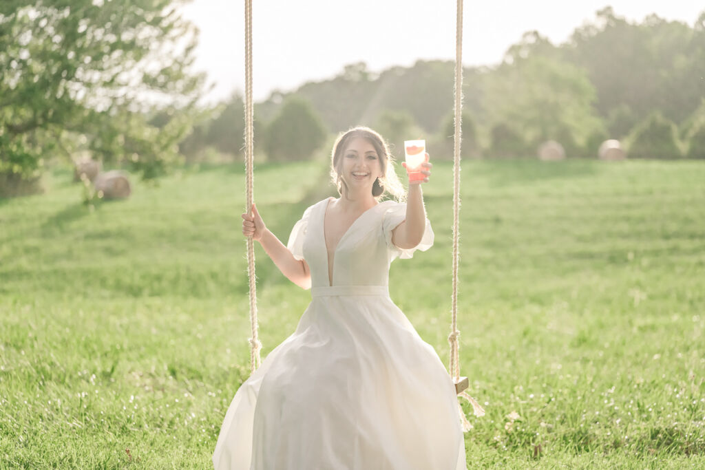 A playful brunette bride enjoying her summer outdoor bridal portrait session at Firefly Haven by JoLynn Photography